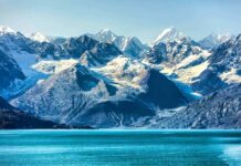 Snow-capped mountains with glaciers above a turquoise lake