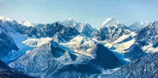 Snow-capped mountains with glaciers above a turquoise lake