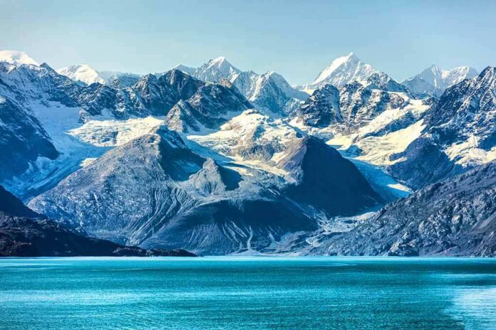 Snow-capped mountains with glaciers above a turquoise lake