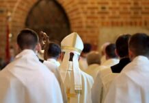 Bishop in white mitre among clergy during church procession