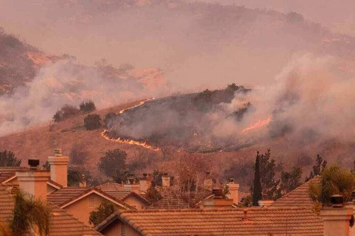 shutterstock_735803347 Wildfire burns on hillside near suburban homes