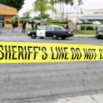 A Department Store Standoff Took a Bizarre Turn yellow sheriff's line tape blocks a street near police cars